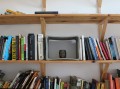 Concrete table placed on wooden bookshelf with books.