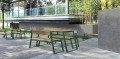 Banc public avec dossier Nørrebro 3 places en bois et métal sur une terrasse extérieure.
