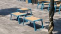 Tabourets d'extérieur Nørrebro bleus et bois sur une terrasse en pierre.