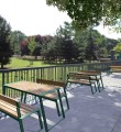 Nørrebro Outdoor Table 150 cm 4-6 Seats with green frame and matching benches on a patio.
