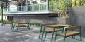 Table de jardin Nørrebro 150 cm en bois et métal avec bancs intégrés, idéale pour 4 à 6 personnes, placée sur une terrasse extérieure.