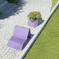 Ørestad Outdoor Planter | 70 l next to a purple garden chair on a stone pathway.