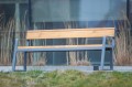 Öffentliche Bank Amager 4-Sitzer mit Holzlehne und Armlehnen im Garten.
