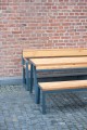 Table d'extérieur Amager 180 cm en bois et métal pour 6-8 personnes, vue sur fond de mur en briques.