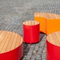 Tabouret d'extérieur Valby 48 cm en métal rouge et bois sur pavé.