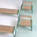 Banc public sans dossier 4 places Nørrebro en bois et métal vert sur fond carrelé.