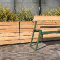 Nørrebro Outdoor Planter | 175 l with wooden panels and green metal frame on a paved surface.