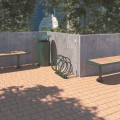 Nordhavn 3-Bike Stand placed outside on brick pavement next to green benches and trash can.