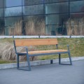 Öffentliche Bank Amager 4-Sitzer mit Rückenlehne und Armlehne auf Gehweg vor moderner Glasfassade.