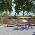 Amager Outdoor Bar Table with stools in a garden setting near the sea.