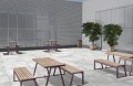 Poubelle de rue Amager sur terrasse moderne avec bancs en bois et arbres en pot.