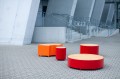 Rote und orange Valby Öffentliche Rückenfreie Bank | Rund auf einem modernen, urbanen Platz.
