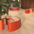 Banc Public Sans Dossier Valby en forme de croissant dans un espace moderne avec des plantes.