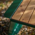Close-up of the Nyboder Outdoor Table 150 cm showing its wooden tabletop and green metal frame.