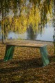 Table d'extérieur Nyboder 180 cm pour 6-8 personnes, en bois, au bord d'un lac avec feuilles d'automne.