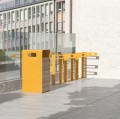 Yellow Nyboder Street Litter Bin with wooden panels placed outdoors.