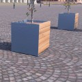 Grand bac à plantes Nyboder en bois et métal sur une place pavée.