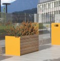 Jardinière extérieure Nyboder de 325 litres en bois et métal jaune, placée sur une terrasse moderne.