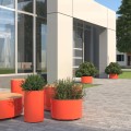 Valby Outdoor Planter for Public Space | 220 l, orange cylindrical planters outside a modern building.