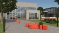 Support vélo Valby rouge installé devant un bâtiment moderne entouré de bancs et de verdure.