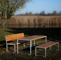 Frederiksberg 4-Sitzer Öffentliche Rückenlehne Bank im Park neben einem Tisch und einer weiteren Bank.