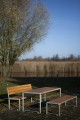Banc public avec dossier Frederiksberg pour 4 personnes en bois et métal dans un parc.