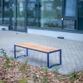 Öffentliche Sitzbank Frederiksberg 3-Sitzer ohne Rückenlehne aus Holz und Metall auf Gehweg.
