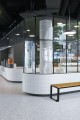 Banc public sans dossier à 3 places Frederiksberg en bois et métal dans un espace moderne.