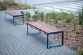 Banc public sans dossier à 3 places Frederiksberg en métal et bois sur un trottoir pavé.