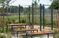 Banc public sans dossier à 3 places Frederiksberg installé dans un parc aménagé.