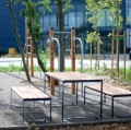 Table d'extérieur Frederiksberg en bois avec bancs dans un cadre moderne et naturel.