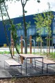 Table d'extérieur Frederiksberg de 150 cm avec bancs, placée dans un espace vert urbain.