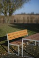 Table d'extérieur Frederiksberg 150 cm en bois et métal dans un jardin.