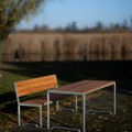 Table d'extérieur Frederiksberg 180 cm avec banc en bois dans un jardin.