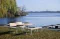 Table d'extérieur Frederiksberg 180 cm avec bancs en bois, située près d'un lac.