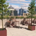 Bacs à plantes en bois sur terrasse avec vue urbaine.