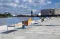 Banc public à trois places Østerbro avec dossier et accoudoirs installé le long d'un quai.