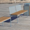 Banc public sans dossier Østerbro 4 places en bois et métal sur plancher extérieur.