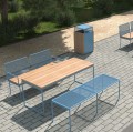 Østerbro 4 Seater Public Backless Bench in an outdoor setting with matching wood and metal table and chairs.