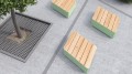 Rechteckige Kødbyen Öffentliche Rückenfreie Bank aus Holz und Metall auf Betonboden.