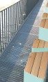 Banc public sans dossier 3 places Kødbyen | Trapézoïde en bois et métal sur une passerelle.