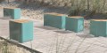 Kødbyen 3-Sitzer öffentliche rückenfreie Bank | Trapez auf einem hölzernen Gehweg am Strand.