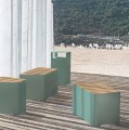 Grüne Kødbyen Straßenmüllbehälter aus Metall mit Holzsitzfläche, platziert auf einer modernen Terrasse.