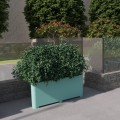 Kødbyen Outdoor Planter | 150 l filled with lush greenery in an outdoor setting.