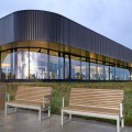 Zweifarbige Hellerup 3-Sitzer Bank mit Rückenlehne und Armlehne vor modernem Gebäude.