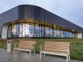 Hellerup 3-Sitzer Bank mit Rückenlehne und Armlehne vor modernem Gebäude.