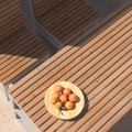 Table d'extérieur Hellerup 180 cm en bois avec plateau de fruits.