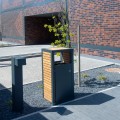 Moderner Hellerup Straßen-Abfallbehälter aus Holz und Metall auf einem Gehweg.