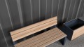 Wooden Indre By 3 Seater Public Backrest Bench next to a matching planter.