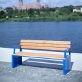 Öffentliche Bank Indre By 4-Sitzer mit blauen Armlehnen am Flussufer.